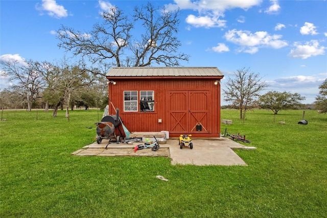 view of outdoor structure featuring a lawn and a rural view