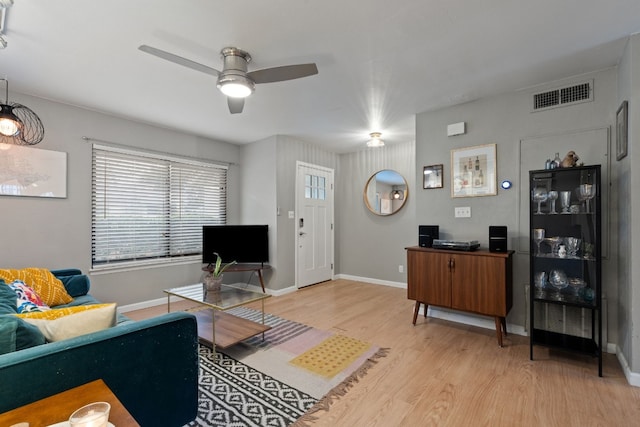 living room featuring light hardwood / wood-style flooring and ceiling fan