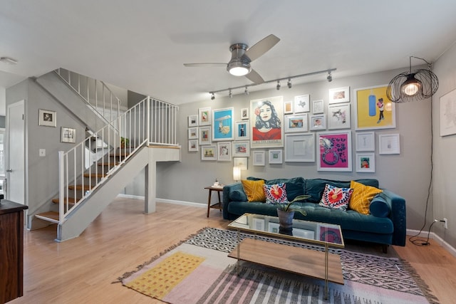 living room featuring wood-type flooring, rail lighting, and ceiling fan