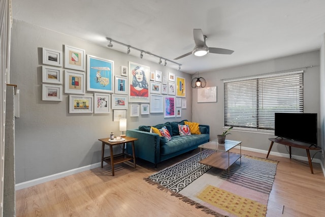 living room with rail lighting, ceiling fan, and light hardwood / wood-style flooring