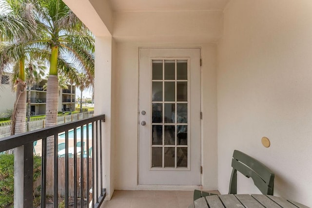 view of exterior entry with a balcony