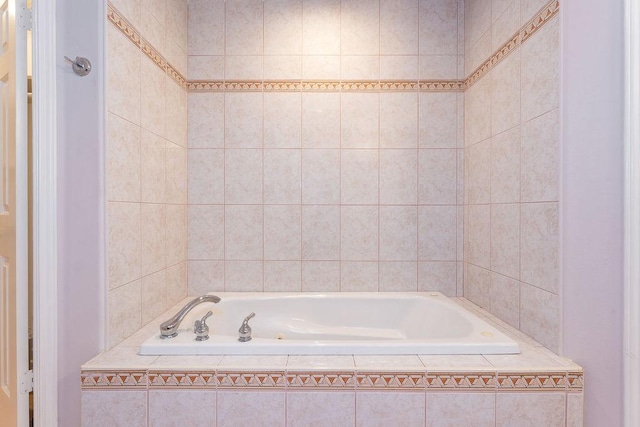 bathroom with a relaxing tiled tub