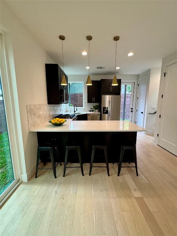 1708 Canterbury St Unit 2, Austin, TX 78702 - kitchen with stainless steel appliances, a sink, light countertops, light wood-style floors, and recessed lighting