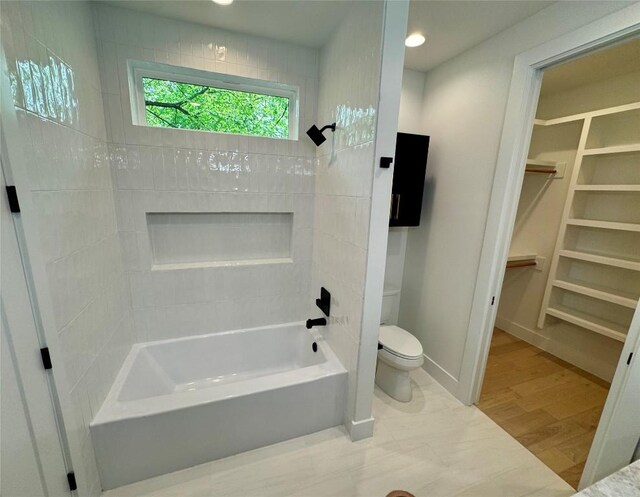 1708 Canterbury St Unit 2, Austin, TX 78702 - bathroom featuring toilet, shower / tub combination, a walk in closet, wood finished floors, and baseboards