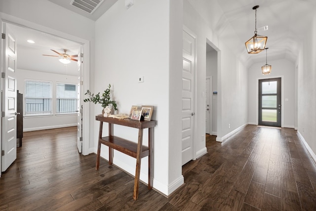 foyer entrance featuring vaulted ceiling, ceiling fan with notable chandelier, and dark hardwood / wood-style flooring