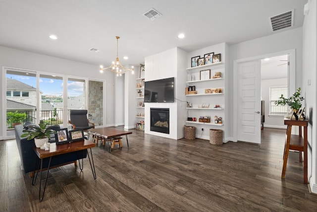 interior space featuring dark wood-type flooring, a notable chandelier, and built in shelves