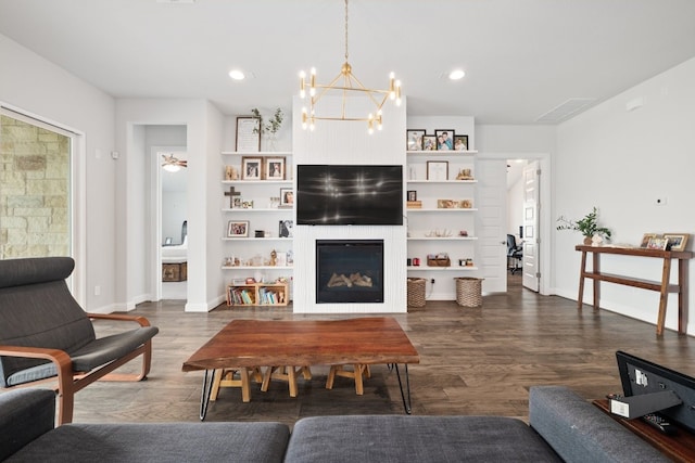 513 Elworth Path, Lakeway, TX 78738 - living area featuring dark wood-style floors, a chandelier, a glass covered fireplace, recessed lighting, and built in shelves