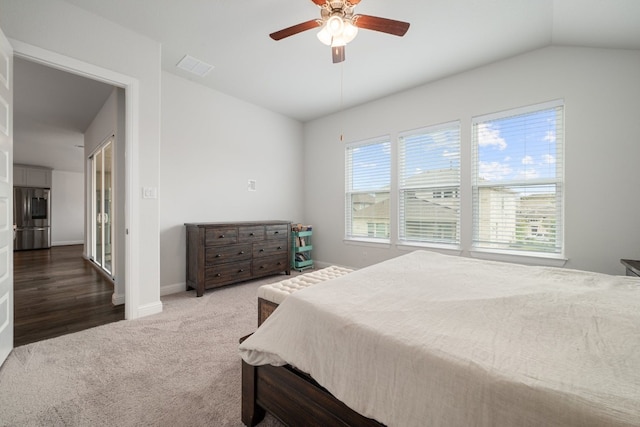 carpeted bedroom with lofted ceiling, stainless steel fridge, and ceiling fan