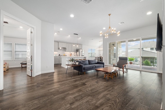 living room with dark hardwood / wood-style flooring and a notable chandelier