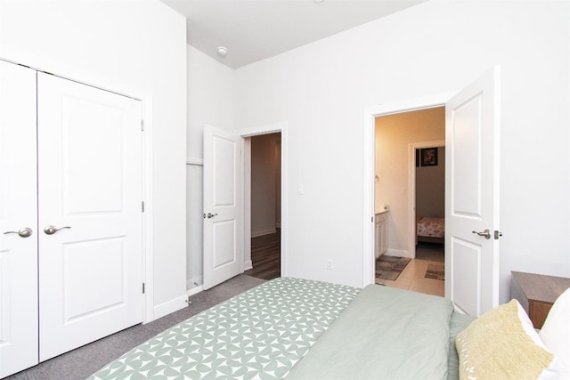 bedroom with connected bathroom, a closet, and carpet flooring