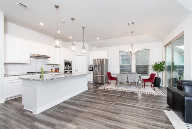 kitchen featuring pendant lighting, sink, appliances with stainless steel finishes, white cabinetry, and an island with sink