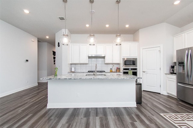 kitchen featuring hanging light fixtures, white cabinetry, appliances with stainless steel finishes, and a center island with sink