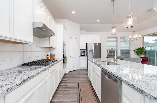 kitchen featuring sink, white cabinetry, light stone counters, pendant lighting, and stainless steel appliances