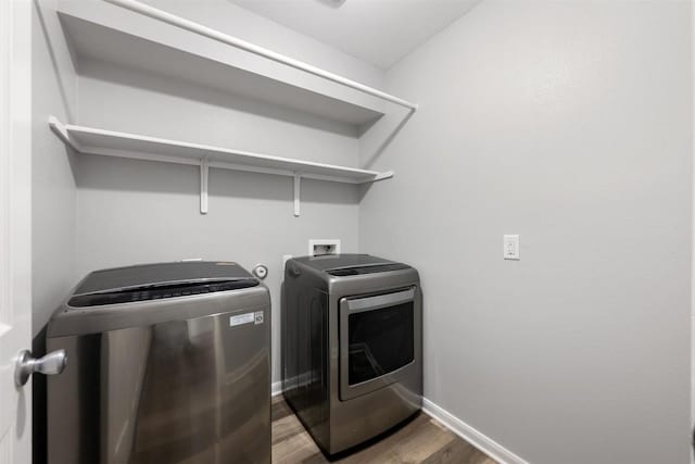 clothes washing area featuring hardwood / wood-style flooring and separate washer and dryer