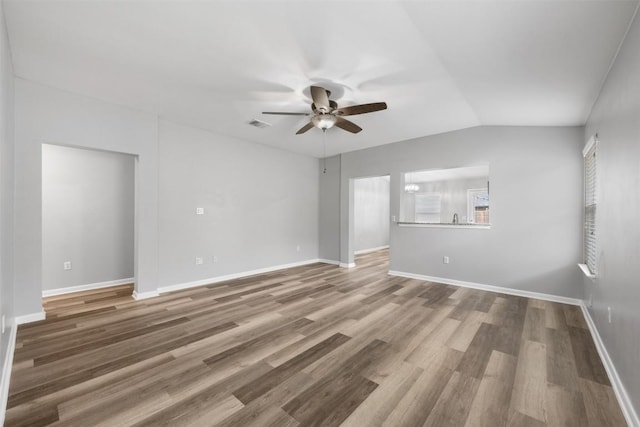 spare room featuring hardwood / wood-style flooring, vaulted ceiling, and ceiling fan