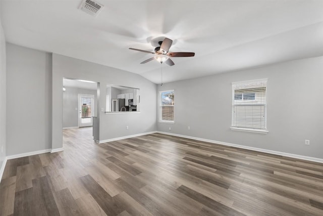 empty room featuring lofted ceiling, hardwood / wood-style floors, plenty of natural light, and ceiling fan