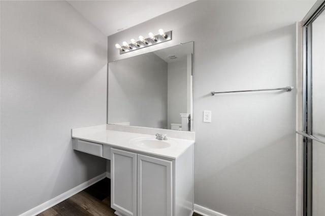 bathroom featuring wood-type flooring, vanity, and toilet