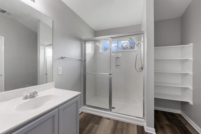 bathroom with vanity, hardwood / wood-style floors, and a shower with door