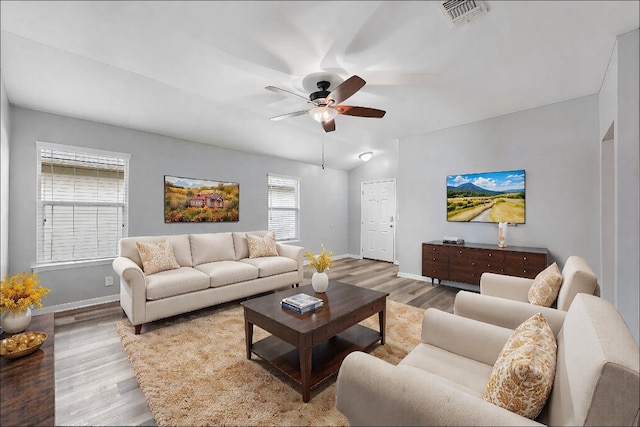 living room with ceiling fan, lofted ceiling, and light wood-type flooring