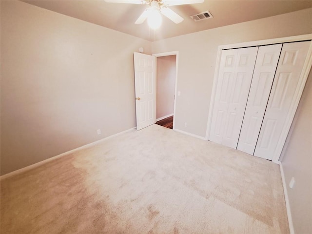 unfurnished bedroom featuring carpet, ceiling fan, and a closet