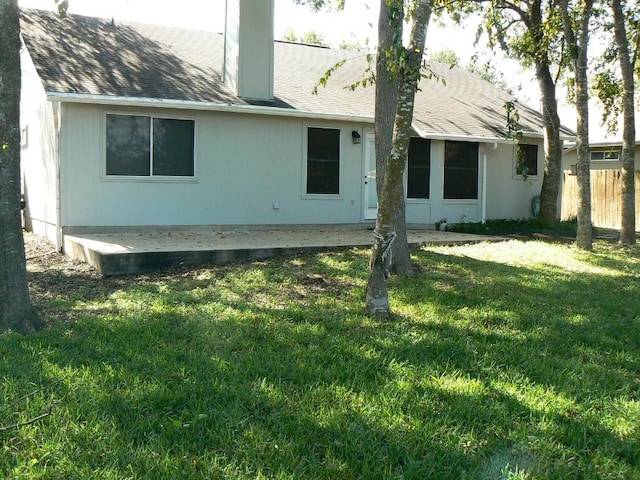 rear view of property featuring a lawn and a patio area