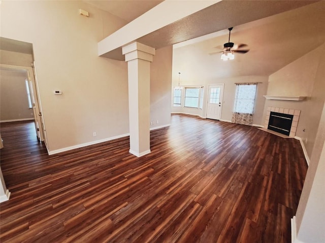 unfurnished living room featuring ornate columns, high vaulted ceiling, a fireplace, dark hardwood / wood-style flooring, and ceiling fan