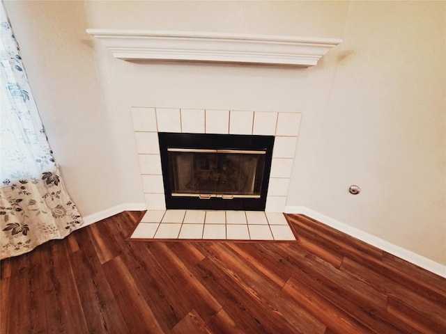 details with a tiled fireplace and hardwood / wood-style flooring