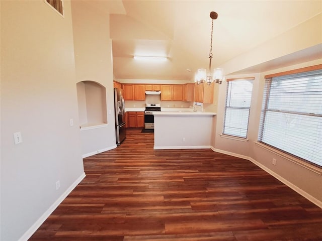 kitchen featuring stainless steel appliances, dark wood-type flooring, an inviting chandelier, and decorative light fixtures