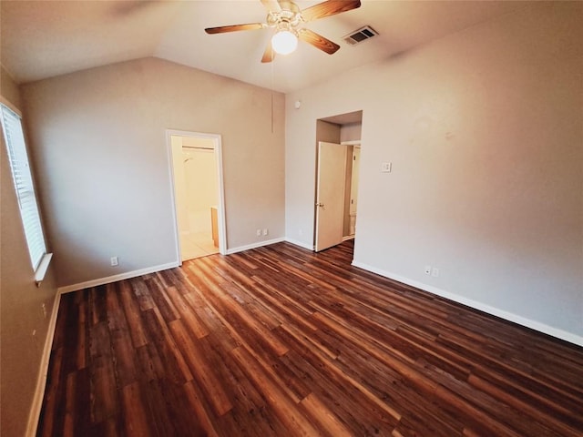 unfurnished bedroom featuring dark wood-type flooring, ceiling fan, connected bathroom, and vaulted ceiling