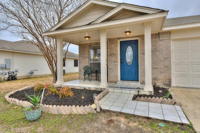 doorway to property featuring a garage and covered porch