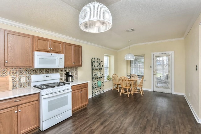 2718 Summerwalk Pl, Round Rock, TX 78665 - kitchen featuring white appliances, dark wood finished floors, decorative backsplash, brown cabinets, and ornamental molding