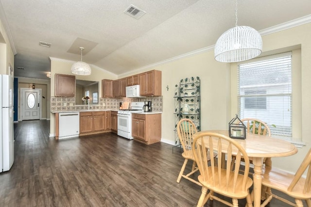 kitchen with pendant lighting, backsplash, white appliances, and dark hardwood / wood-style floors