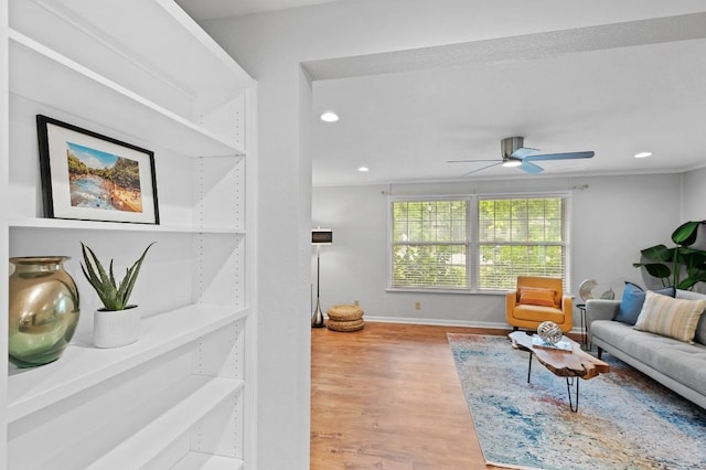 living room with hardwood / wood-style flooring, ornamental molding, and ceiling fan