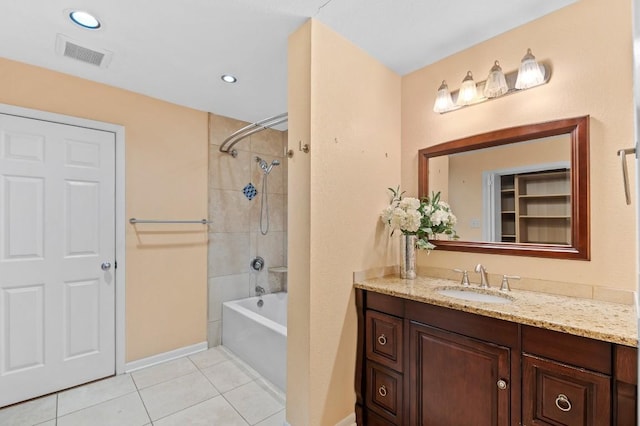 bathroom featuring vanity, tiled shower / bath combo, and tile patterned floors