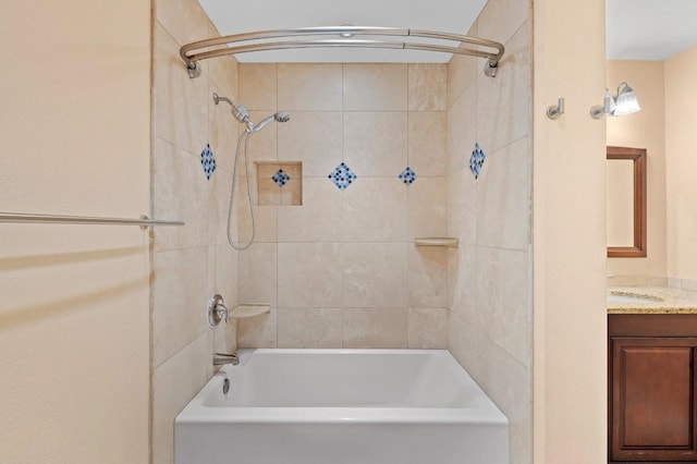 bathroom featuring tiled shower / bath combo and vanity