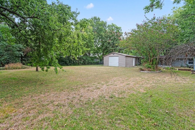 view of yard featuring a garage and an outbuilding