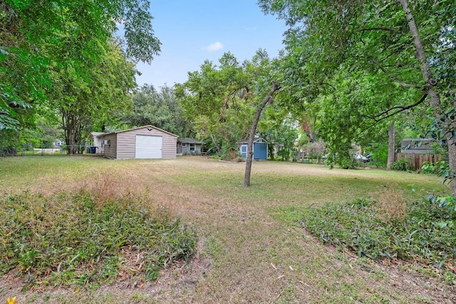 view of yard featuring a garage and a storage unit