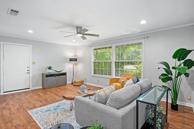 living room with crown molding, wood-type flooring, and ceiling fan