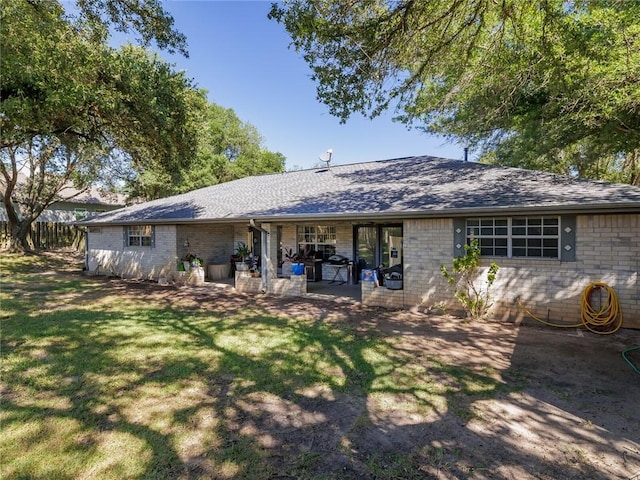 rear view of house with a patio area and a lawn