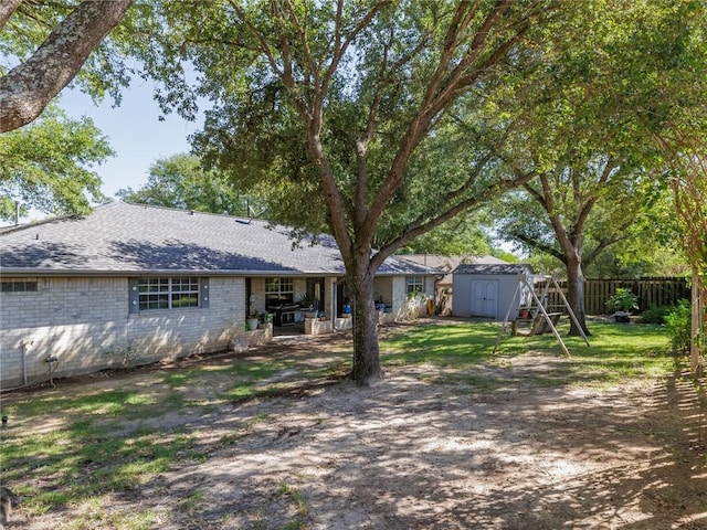 rear view of house with a storage shed and a patio