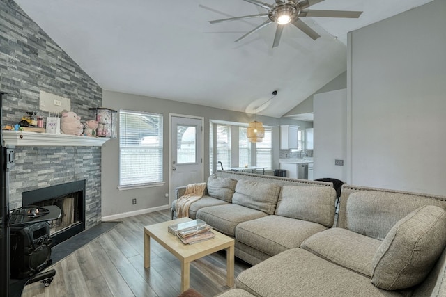 living room with ceiling fan, high vaulted ceiling, wood-type flooring, and a fireplace