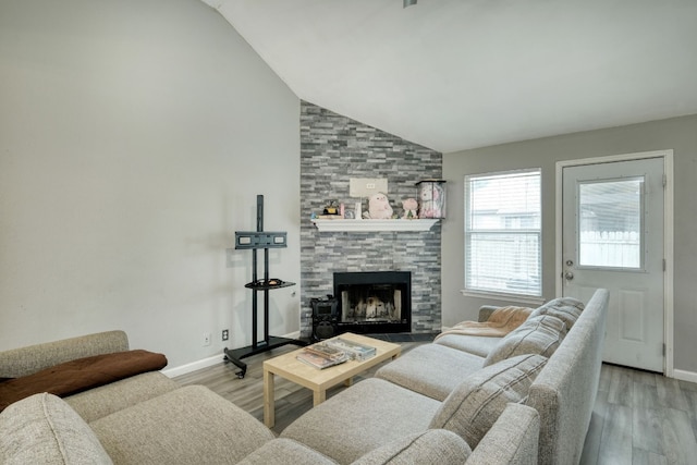 living room featuring light wood-type flooring, high vaulted ceiling, and a large fireplace