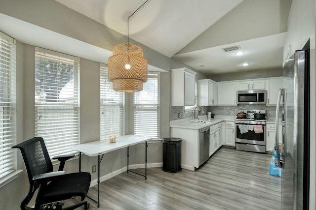 kitchen with white cabinetry, sink, stainless steel appliances, and pendant lighting