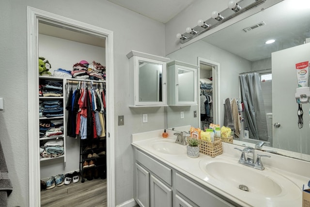 bathroom with hardwood / wood-style floors, a shower with curtain, and vanity