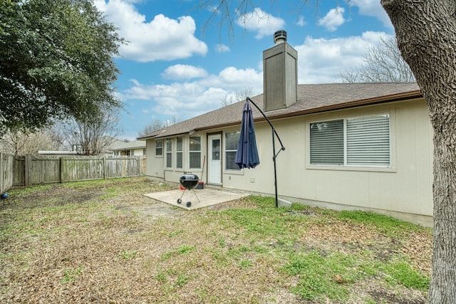 back of house with a patio and a lawn