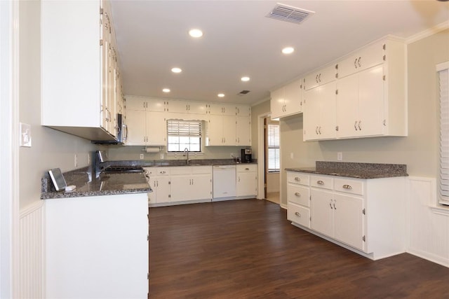 kitchen featuring dark wood-type flooring, stove, white dishwasher, and white cabinets