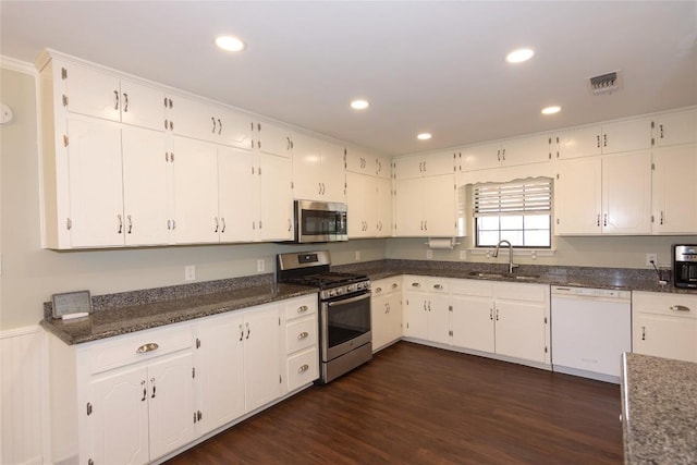 kitchen with stainless steel appliances, white cabinetry, sink, and dark hardwood / wood-style flooring