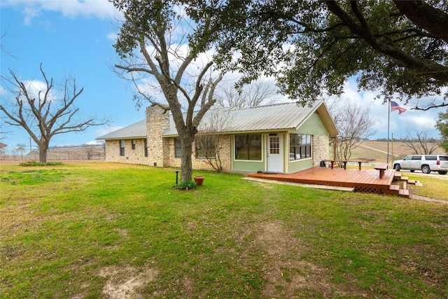 rear view of property with a lawn and a deck