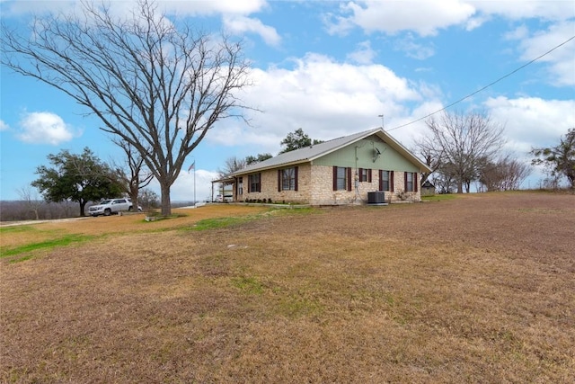 view of property exterior featuring central AC and a lawn