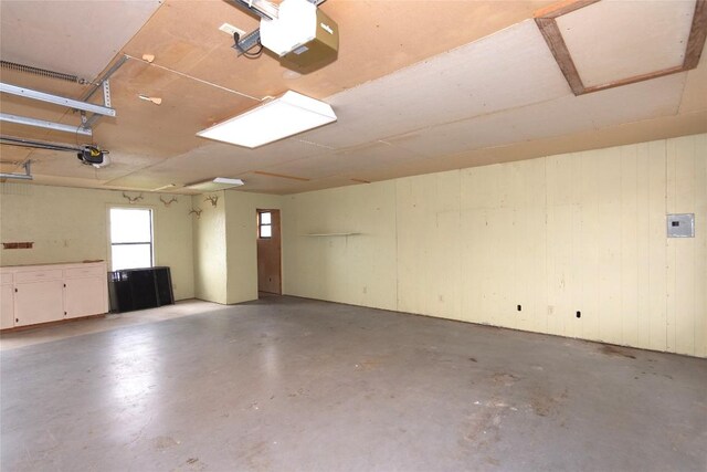 garage with a garage door opener and wooden walls